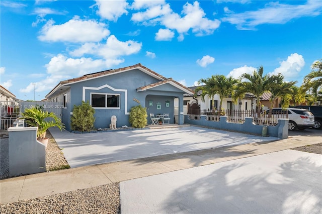 view of front of home featuring fence private yard, stucco siding, and a tiled roof