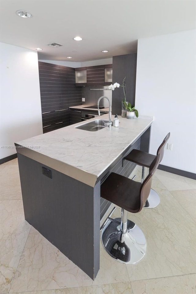 200 S Biscayne Blvd Unit 3903, Miami, FL 33131 - kitchen featuring modern cabinets, light countertops, a breakfast bar, a peninsula, and recessed lighting