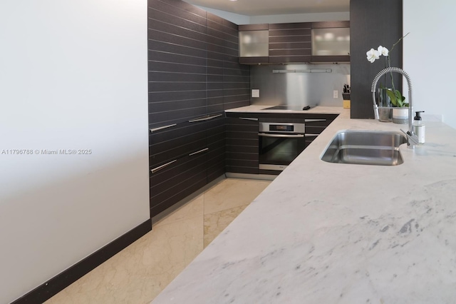 200 S Biscayne Blvd Unit 3903, Miami, FL 33131 - kitchen with oven, modern cabinets, glass insert cabinets, light stone countertops, and black electric cooktop
