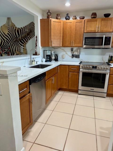 12815 SW 71st Ln, Miami, FL 33183 - kitchen featuring appliances with stainless steel finishes, a sink, light countertops, and light tile patterned floors