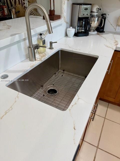 12815 SW 71st Ln, Miami, FL 33183 - kitchen view of a sink, brown cabinetry, and light stone countertops