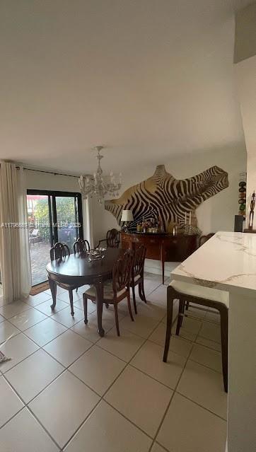 dining room featuring a notable chandelier and light tile patterned flooring
