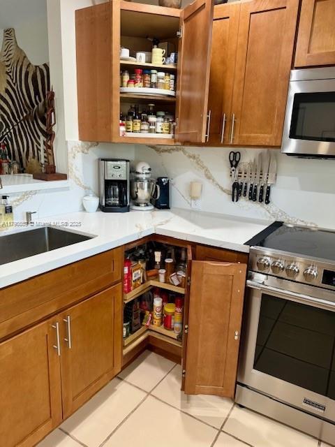 12815 SW 71st Ln, Miami, FL 33183 - kitchen with stainless steel appliances, open shelves, light countertops, and brown cabinets