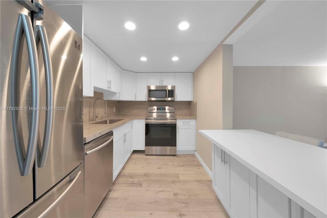 200 Galen Dr Unit 308, Key Biscayne, FL 33149 - kitchen with a sink, light wood-type flooring, white cabinetry, appliances with stainless steel finishes, and recessed lighting