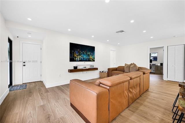 living area featuring light wood-style flooring, baseboards, visible vents, and recessed lighting
