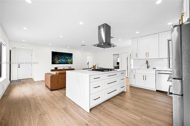 kitchen with stainless steel appliances, light wood-type flooring, a sink, and island exhaust hood