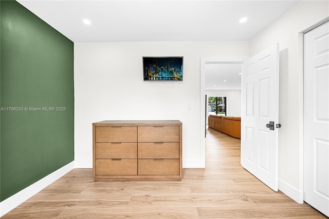 hall with baseboards, light wood finished floors, and recessed lighting