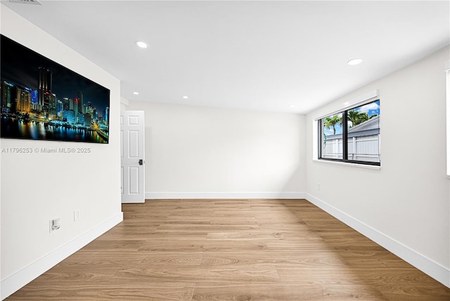 spare room with baseboards, recessed lighting, and wood finished floors
