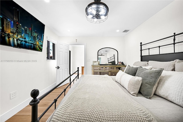 bedroom featuring visible vents, wood finished floors, baseboards, and recessed lighting