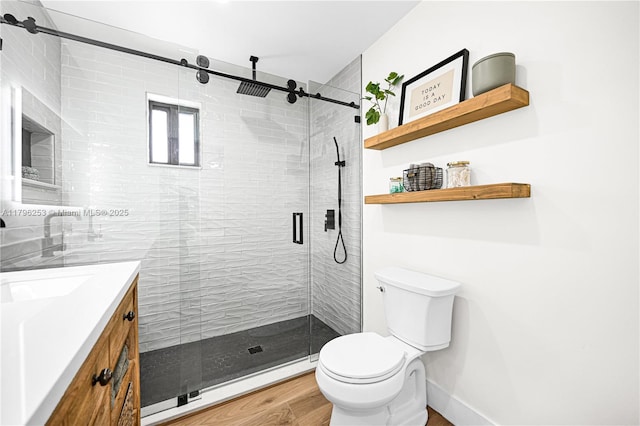 full bath with toilet, vanity, and a stall shower