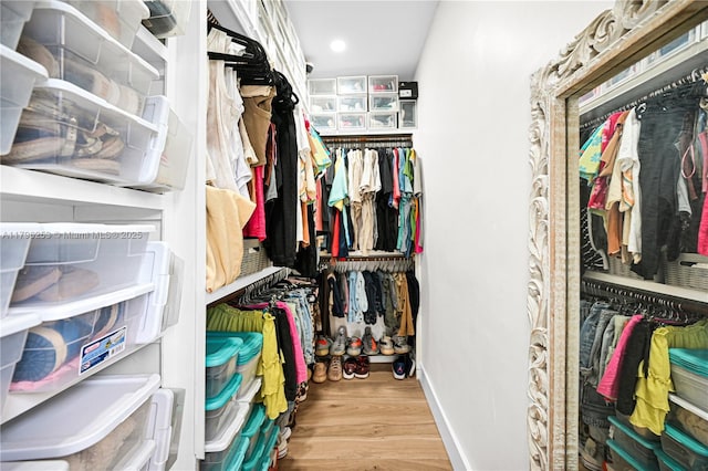 walk in closet with wood finished floors