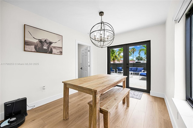dining space with french doors, an inviting chandelier, light wood-style flooring, and baseboards