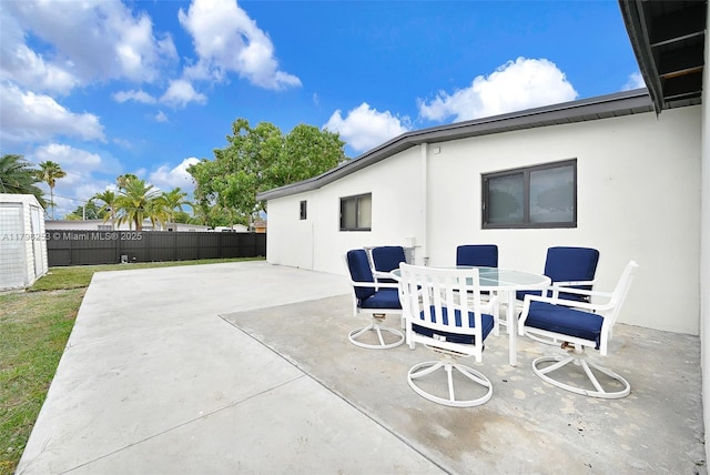 view of patio with outdoor dining area and fence