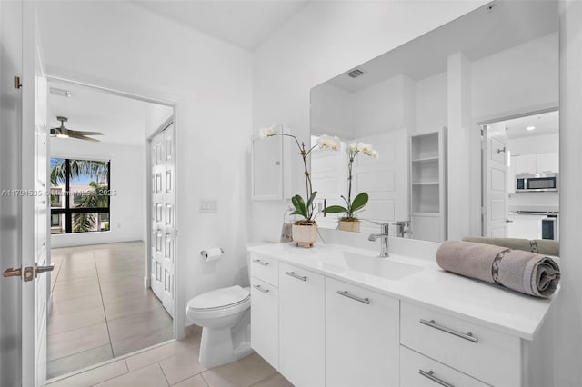 bathroom with a ceiling fan, toilet, visible vents, tile patterned flooring, and vanity