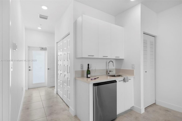 hall featuring a sink, light tile patterned flooring, visible vents, recessed lighting, and baseboards