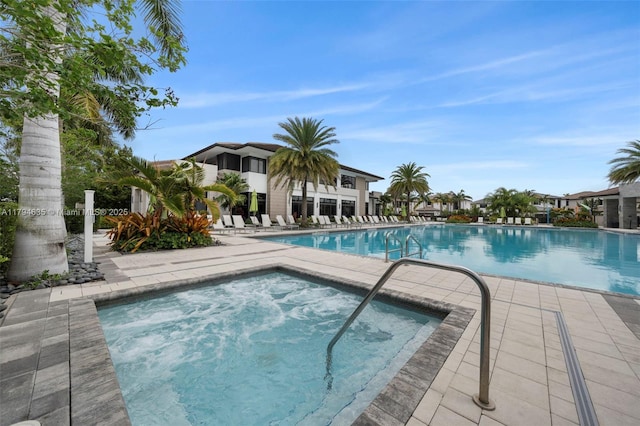 community pool with a patio area and a community hot tub