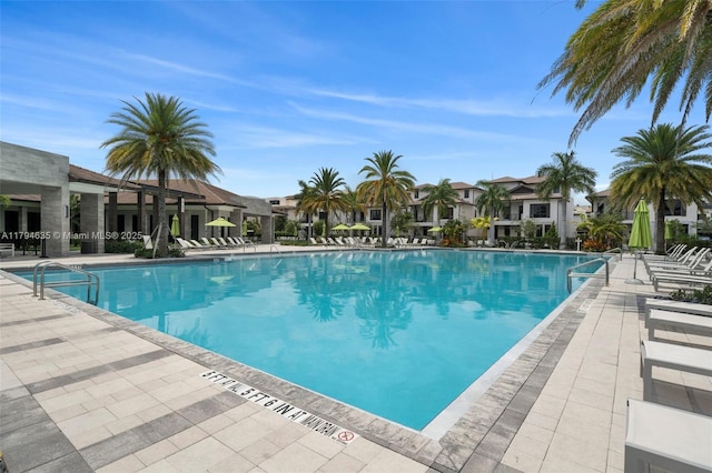 community pool with a patio area and a residential view