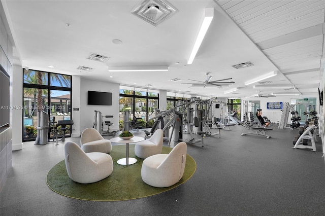 gym with a ceiling fan, a healthy amount of sunlight, and visible vents