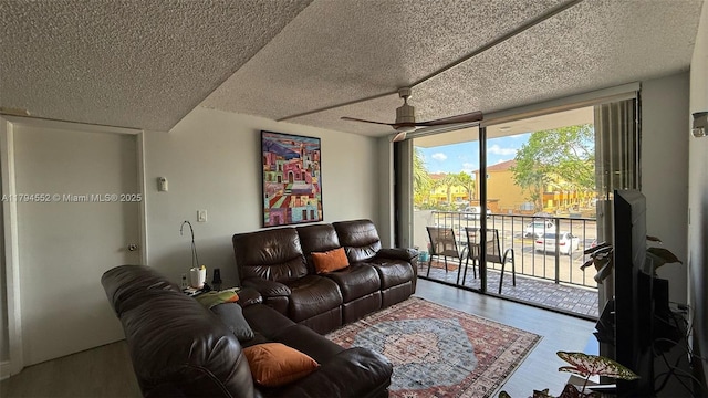 living room with a ceiling fan, a textured ceiling, and wood finished floors