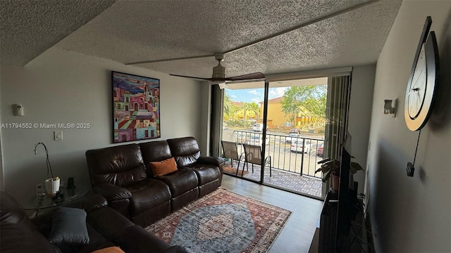 living room featuring a textured ceiling, a ceiling fan, and wood finished floors