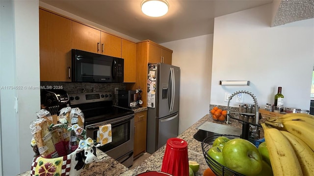 kitchen with backsplash, brown cabinets, appliances with stainless steel finishes, and a sink