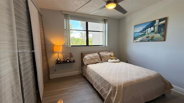 bedroom with baseboards, ceiling fan, and wood finished floors
