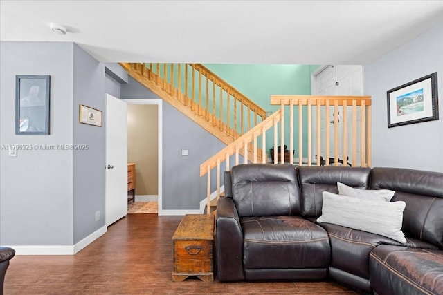 living area with baseboards, stairs, and wood finished floors