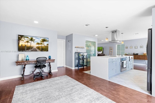 kitchen featuring black appliances, visible vents, ventilation hood, open floor plan, and a center island