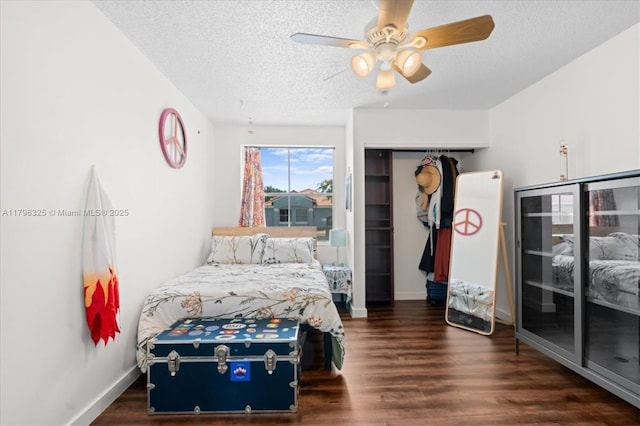 bedroom featuring a textured ceiling, baseboards, a ceiling fan, and wood finished floors