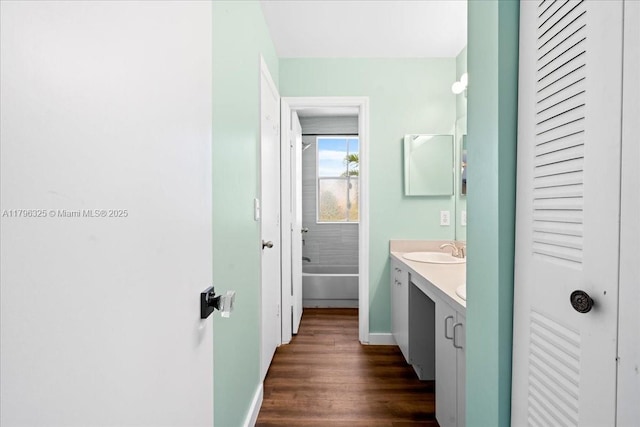 full bathroom featuring vanity, baseboards, a tub to relax in, and wood finished floors