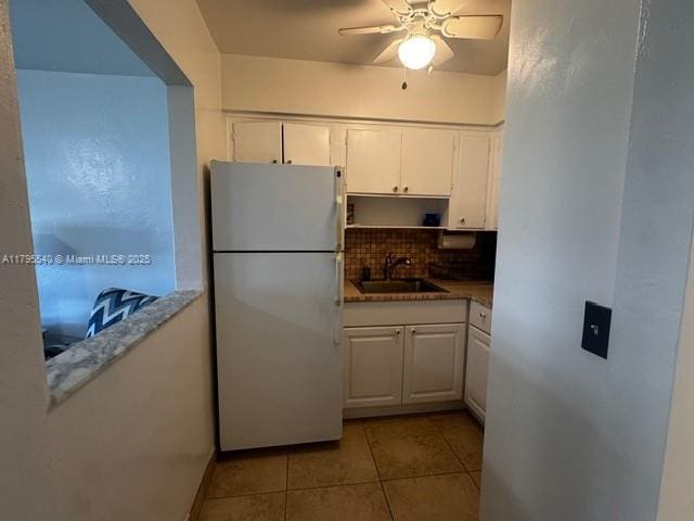 801 Atlantic Shores Blvd Unit 115, Hallandale Beach, FL 33009 - kitchen with freestanding refrigerator, backsplash, light tile patterned floors, and white cabinetry