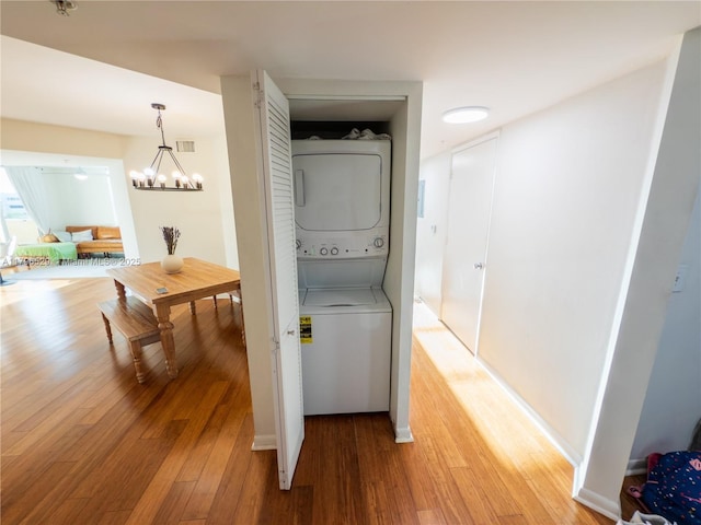 520 SE 5th Ave Unit 3302, Fort Lauderdale, FL 33301 - laundry room featuring stacked washer / dryer, laundry area, visible vents, a chandelier, and light wood-style floors