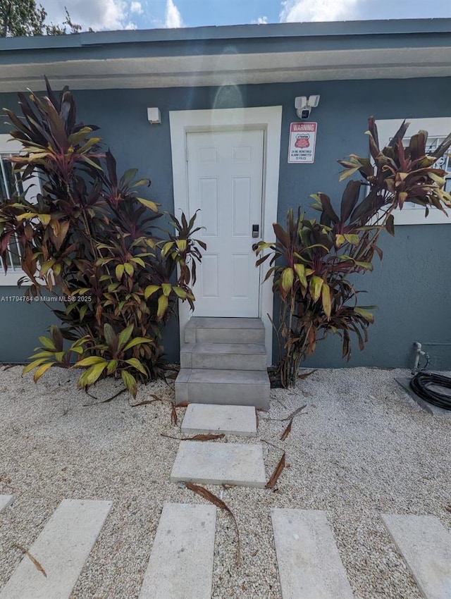 property entrance with stucco siding