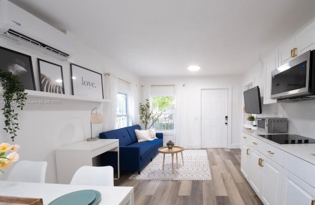 living area featuring light wood finished floors, a wall mounted AC, and recessed lighting