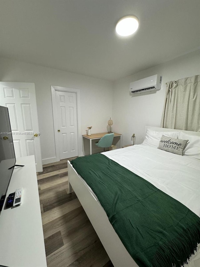 bedroom featuring a wall mounted air conditioner and dark wood-type flooring