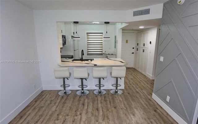 3688 N University Dr Unit H-3, Coral Springs, FL 33065 - kitchen featuring baseboards, visible vents, a kitchen bar, white cabinetry, and black microwave