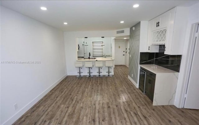 3688 N University Dr Unit H-3, Coral Springs, FL 33065 - kitchen featuring wood finished floors, white cabinets, baseboards, light countertops, and recessed lighting