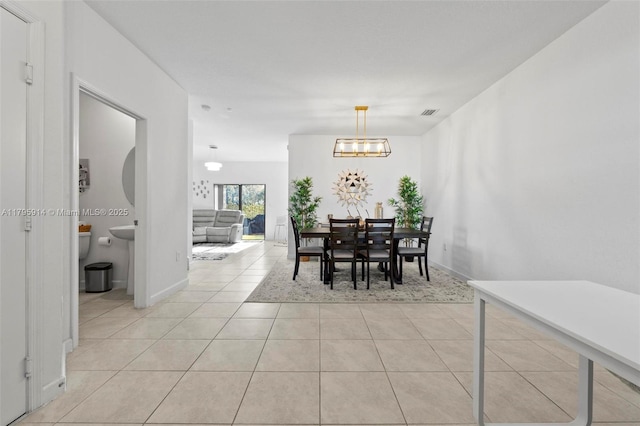 dining area featuring baseboards, visible vents, a chandelier, and light tile patterned flooring