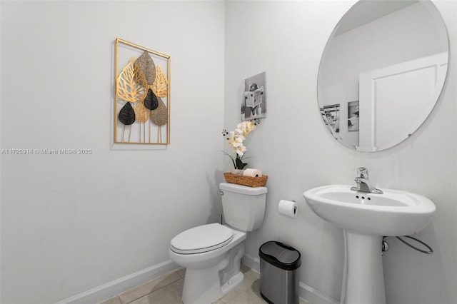 bathroom with a sink, tile patterned flooring, toilet, and baseboards