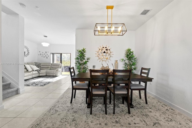 dining room featuring light tile patterned floors, a notable chandelier, visible vents, baseboards, and stairs