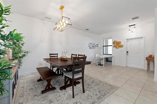 dining room with an inviting chandelier, light tile patterned floors, and visible vents