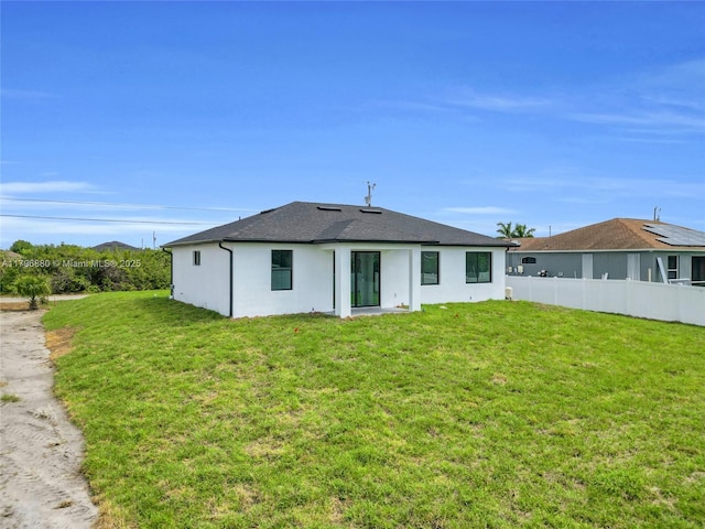 4115 20th St SW, Lehigh Acres, FL 33397 - back of house with a shingled roof, a yard, stucco siding, and fence