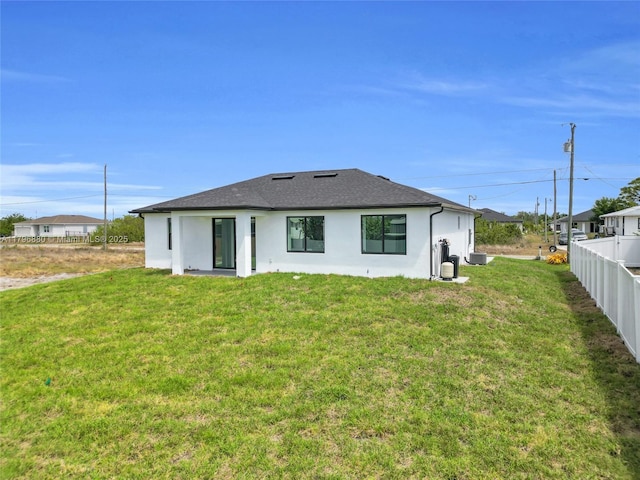 4115 20th St SW, Lehigh Acres, FL 33397 - back of house featuring a yard, stucco siding, a shingled roof, and fence