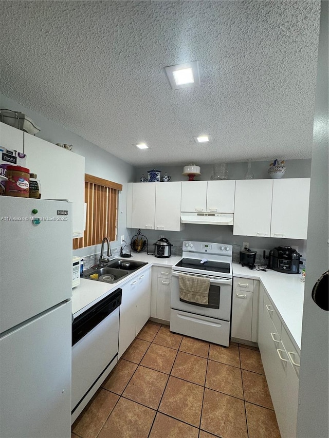 kitchen with white appliances, under cabinet range hood, light countertops, and a sink