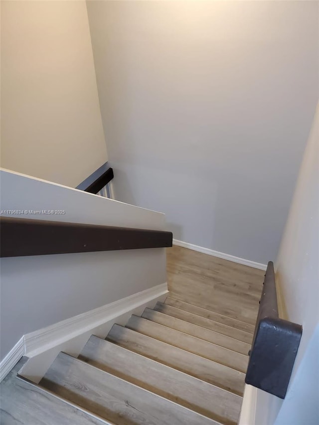 stairway featuring baseboards and wood finished floors