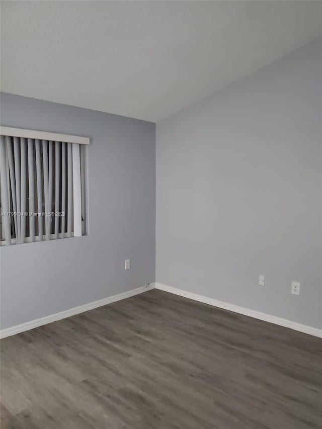 empty room featuring baseboards and wood finished floors