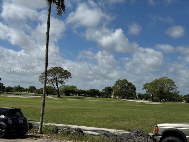 view of property's community with a yard and view of golf course