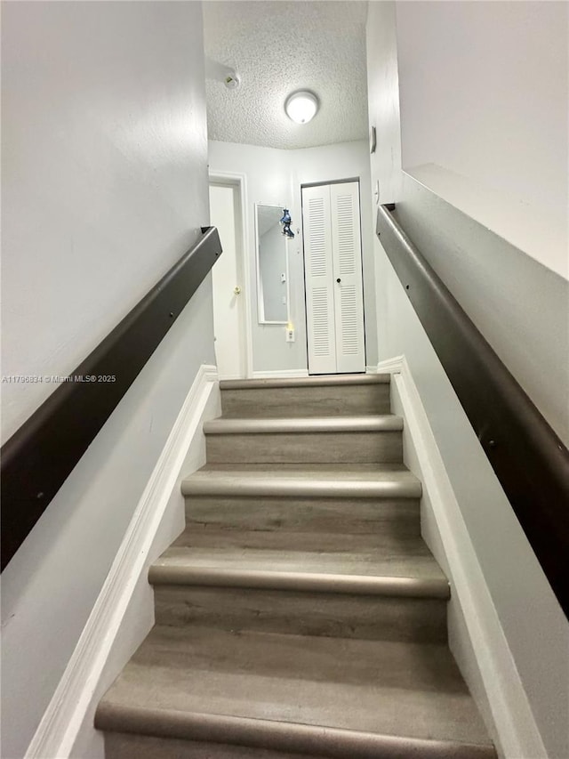 stairway with a textured ceiling