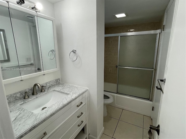 full bath featuring tile patterned floors, toilet, vanity, and combined bath / shower with glass door