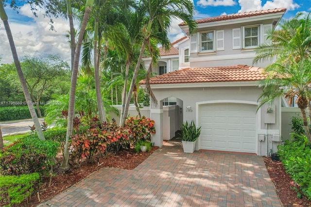1110 Canella Ln, Hollywood, FL 33019 - mediterranean / spanish home featuring fence, an attached garage, a tile roof, stucco siding, and decorative driveway